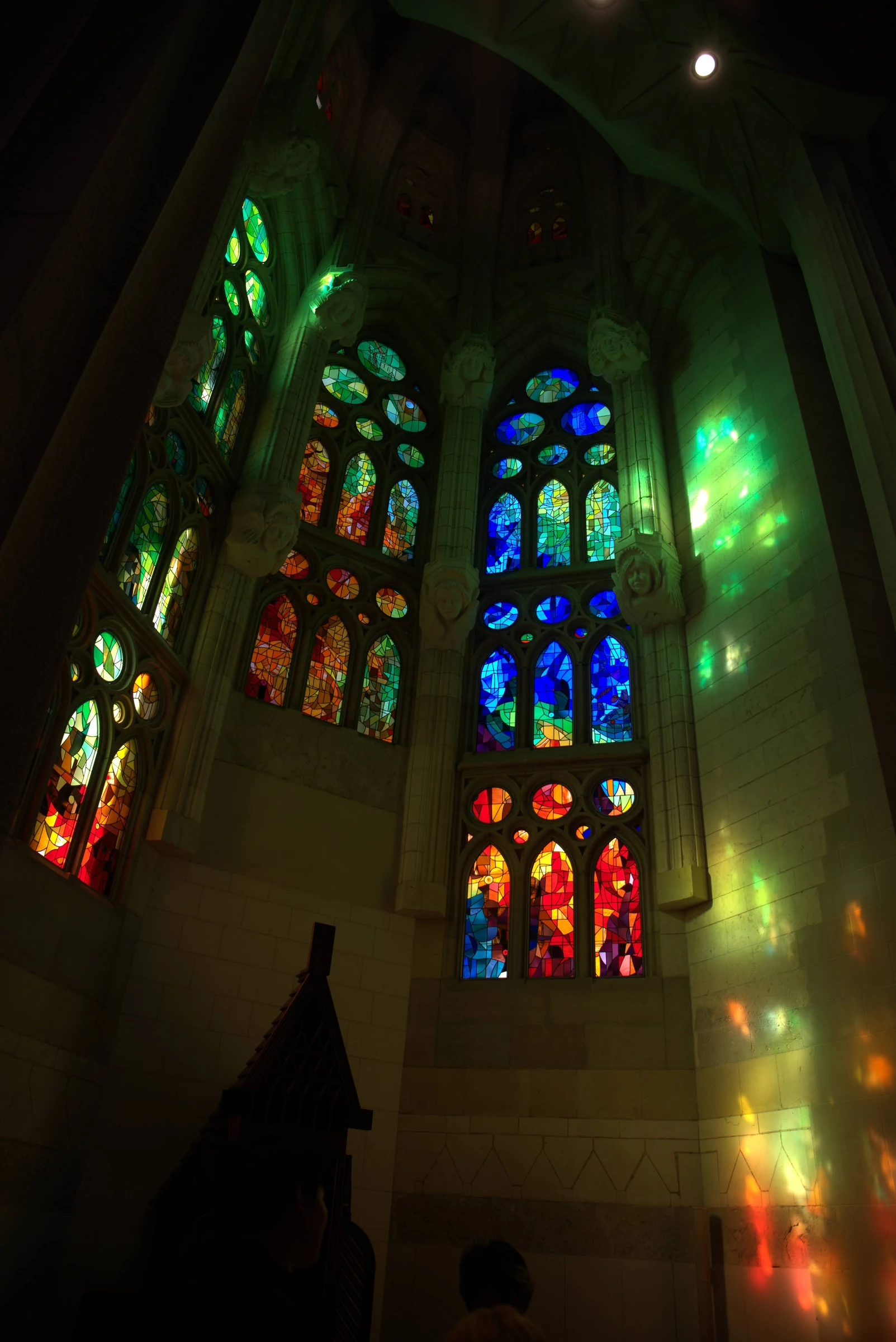 Colored light from the stained-glass windows filling the interior of Sagrada Familia.