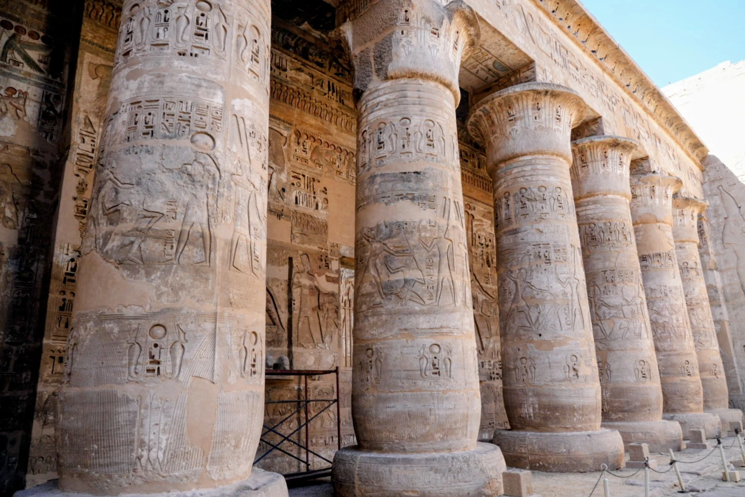 A colonnade of carved hieroglyphic columns in an ancient Egyptian temple.