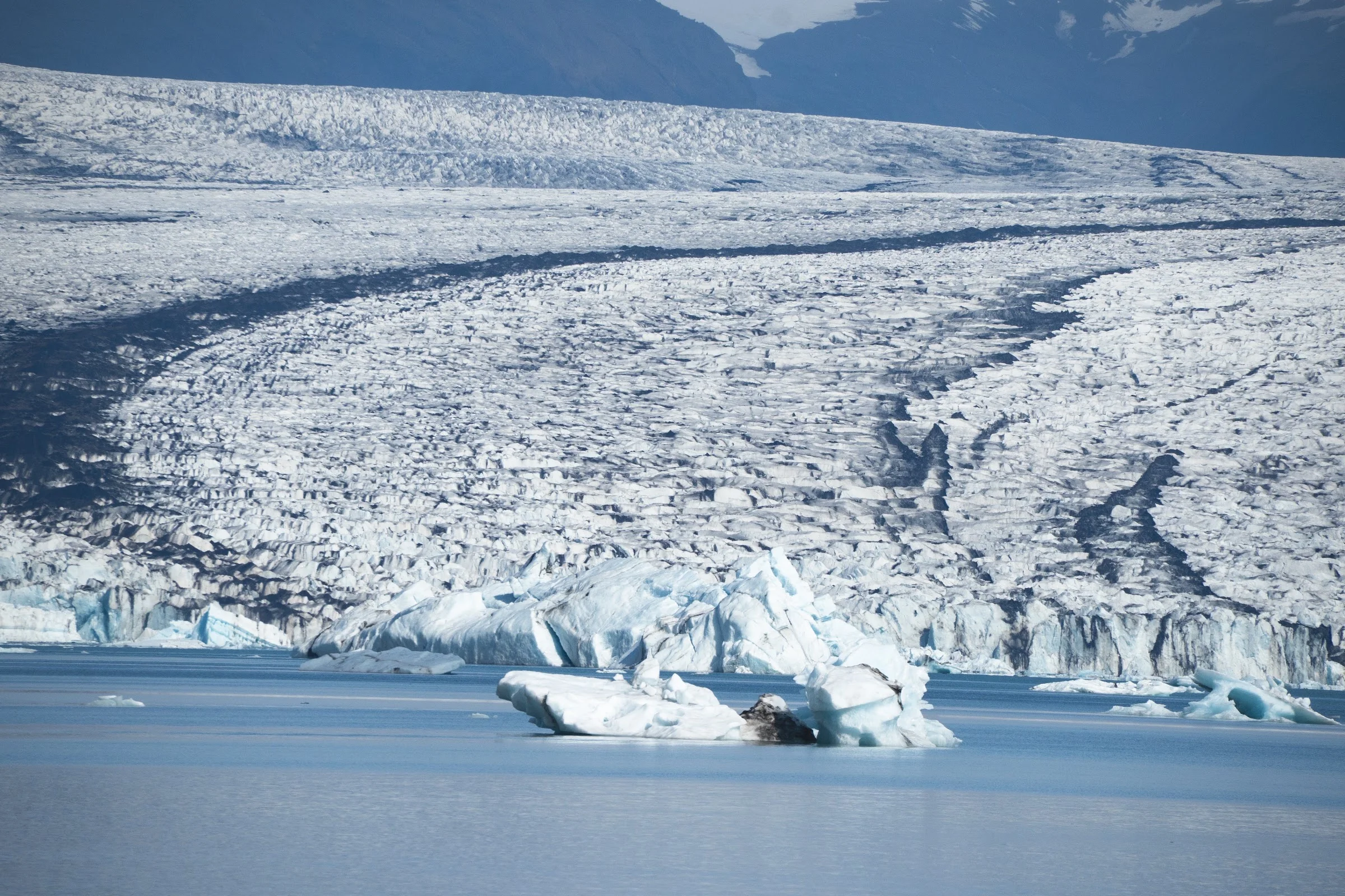 Deep crevasses running through a glacier face.